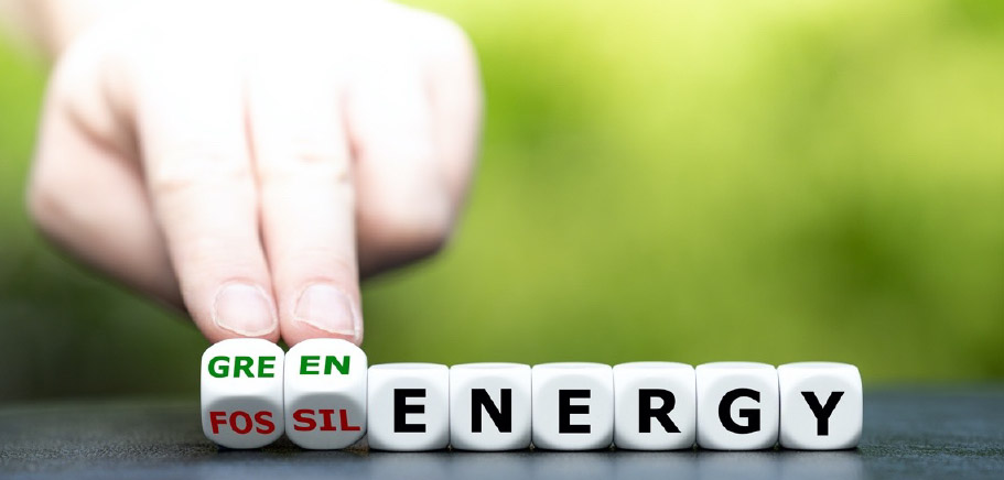 A green background. In the front, a hand showing dices with the letters saying green and fossil energy.