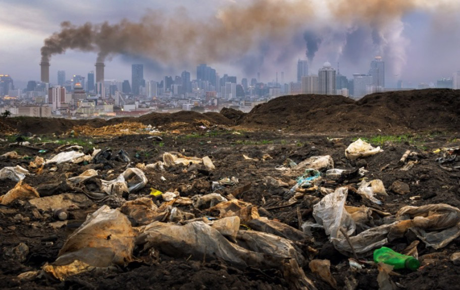 Picture a field full of garbage and in the background a city with chimneys belching smoke.